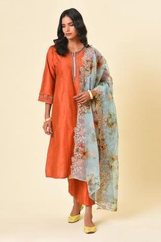 Rust art silk kurta with antique fine metal bead embroidery on front and sleeves, with light blue trimmings and side pocket. Paired with straight pant and contrast light blue printed organza dupatta with cutwork hem.
Component: 3
Embroidered, Printed
Neckline: Notched
Sleeve Length: Three Quarter
Fabric: Art Silk, Organza
Color: Orange, Blue
Placement embroidered kurta
Side slit kurta
Embroidered dupatta hem
Side pocket kurta - Aza Fashions Rust Art, Printed Dupatta, Silk Bottoms, Indian Makeup, Straight Kurta, Orange Art, Organza Dupatta, Kurta With Pants, Silk Dupatta