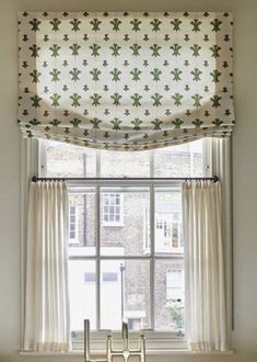 a kitchen window with an open valance over the top and two chairs in front of it