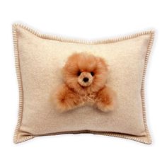 a teddy bear is sitting on top of a pillow