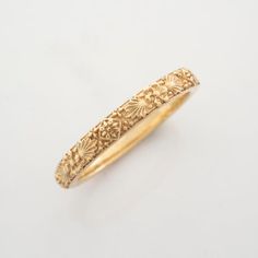 an antique gold wedding band with floral designs