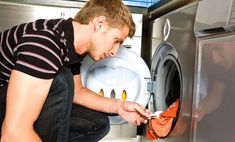 a man is looking into an open washing machine