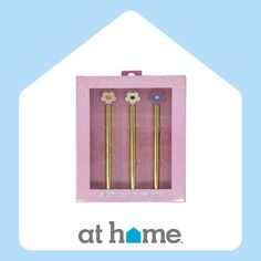 two gold colored metal straws in a pink box with flowers on the top and bottom