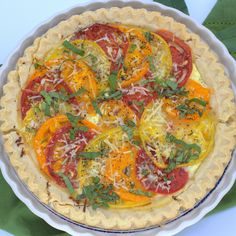 a pie with tomatoes, cheese and herbs on top