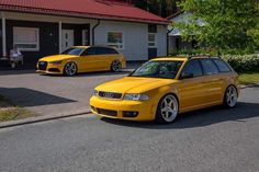 two yellow cars parked in front of a house