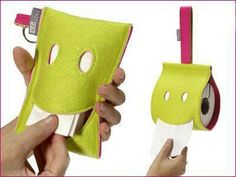 two people holding small green items with eyes on them and one has a toothbrush holder in the other hand