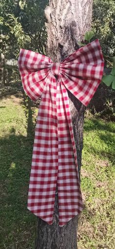 a red and white gingham bow tied to a tree