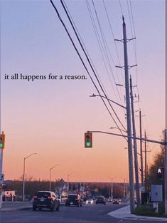 a traffic light sitting above a street next to power lines and telephone poles with a quote written on it