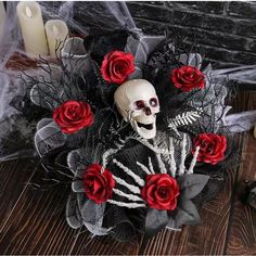 a skeleton with red roses in its hair on a table next to candles and other decorations