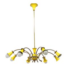 a yellow chandelier with six lights hanging from it's center and four arms