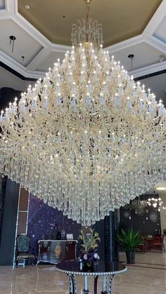 a large crystal chandelier hanging from the ceiling in a hotel lobby with marble flooring