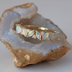 an opalite and diamond ring sitting on top of a rock