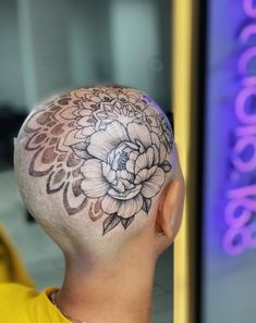 a man with a flower tattoo on his head