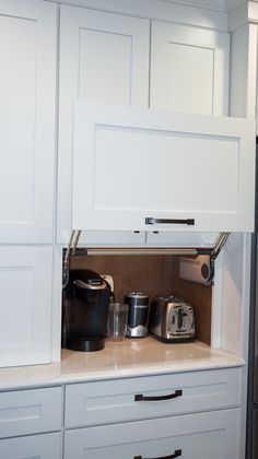 a kitchen with white cabinets and appliances in it