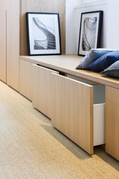 a wooden desk with drawers and pictures on the wall