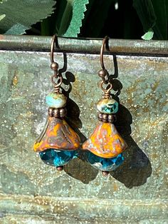 "Perfect dainty earrings to help us think of Spring flowers!!  These beautiful lightweight drop earrings are made with large blue fire-polished Czech glass topped with more light brown Czech glass in the shape of a flower with more copper and a small Czech bead.  A fun combination that you can wear with anything and sparkle!!  I love Czech glass - each bead is like a piece of artwork to me, so I have a lot of fun creating with them! **Each piece of Daisy Light Jewelry is delivered packaged in a brown kraft box with a double organza bow and charm.  If you have two or more boxes, I will note what is in each box for easy gift giving. **If you want Christmas color organza ribbon and Christmas charm, please make a note to me at checkout (silver, white, red, and/or green) **My \"professional pho Blue Teardrop Bohemian Flower Earrings, Blue Bohemian Teardrop Flower Earrings, Bohemian Blue Teardrop Flower Earrings, Blue Dangle Earrings With Bead Caps, Blue Bead Cap Drop Earrings, Unique Blue Flower Earrings With Ear Wire, Bohemian Blue Flower Earrings With Dangling Beads, Blue Teardrop Flower Earrings With Ear Wire, Blue Picasso