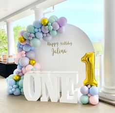 a balloon arch with the number one on it