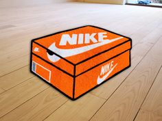 an orange nike box rug sitting on top of a wooden floor