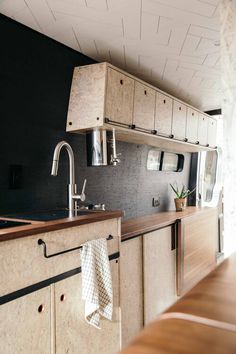 a kitchen with wooden cabinets and black walls