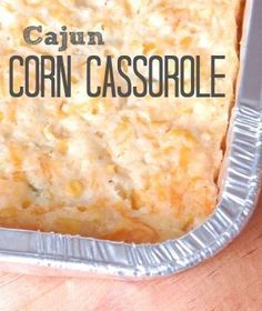 a casserole in a metal pan on top of a wooden table with the words cajun corn casserole