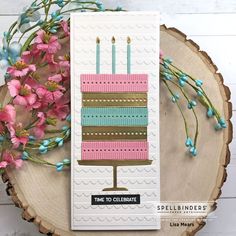 a card with a birthday cake on it next to some pink flowers and blue berries