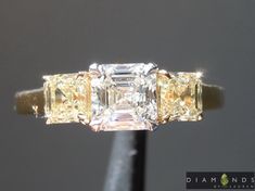 CENTER STONE: WEIGHT: 0.72ct QUANTITY: 1 TYPE: Diamond SHAPE: Asscher Cut COLOR: G CLARITY: SI2 MEASUREMENTS: 5.70 x 5.40 mm SIDE STONES: TOTAL WEIGHT: 0.78cts QUANTITY: 2 TYPE: Diamond SHAPE: Asscher Cut COLOR: Fancy Light Yellow CLARITY: VS MEASUREMENTS: 3.90 x 3.90 mm MOUNTING: Platinum and 18 Karat Yellow Gold Currently sized at: 6 We will ship the ring in your size. We start with a gorgeous colorless Asscher in the center - the diamond is an eye clean SI2. The center and Light Canary sides are all beautifully cut - very "steppy" The custom made ring fits the diamonds perfectly. The lovely shaped claws are unobtrusive, yet totally secure. We used an 18kt yellow gold shank on this puppy. An Asscher Lover's Dream ring. Asscher Cut Diamond Ring, Fancy Light, Asscher Cut Diamond, Fancy Lights, Asscher Cut, Ring Fit, Dream Ring, Diamond Shape, Light Yellow