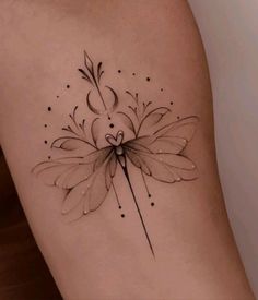 a woman's thigh with a flower tattoo on it and an arrow in the center