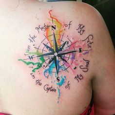 a woman's back with a colorful compass tattoo on it