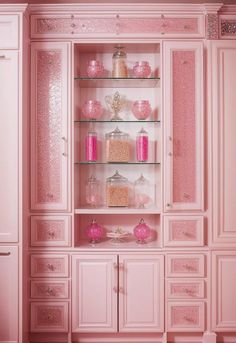 a pink china cabinet with glass shelves and drawers