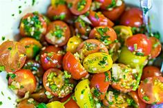 a white bowl filled with lots of different types of tomatoes