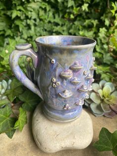 a blue vase sitting on top of a rock