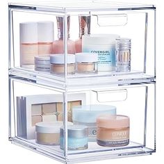 clear acrylic storage bins filled with cosmetics and skin care products on white background