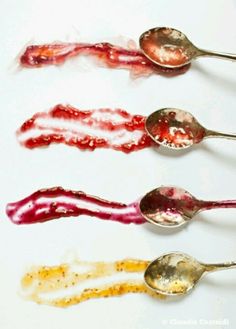 four spoons with different colored food on them