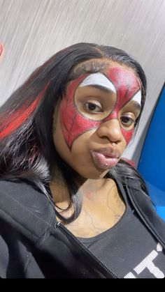 a woman with her face painted like spiderman