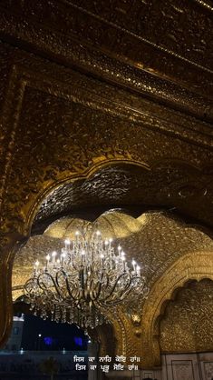 a chandelier hanging from the ceiling in a room with gold walls and ceilings