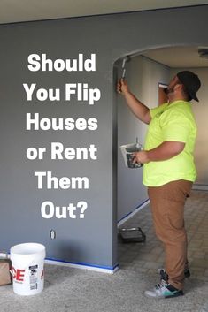 a man in yellow shirt painting a wall with white paint and the words should you flip houses or rent them out?