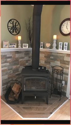 there is a wood stove in the living room with two clocks on the wall behind it