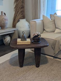 a living room with a couch, coffee table and vases on the side tables