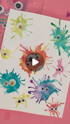 an art project with paint splattered on paper and eyeballs in the middle