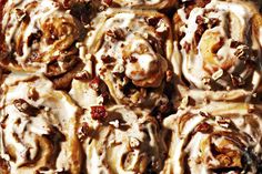 cinnamon rolls with icing and pecans on top in a baking pan, ready to be eaten