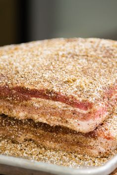 two pieces of meat sitting on top of a metal pan covered in seasoning powdered sugar