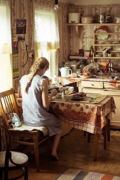 a woman sitting at a table in a kitchen