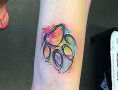 a woman's arm with a colorful tattoo design on the left side of her wrist