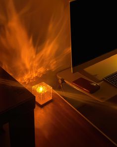 a computer desk with a lamp on it next to a laptop