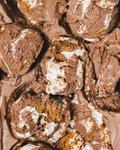 chocolate cookies with white frosting and sprinkles on top, arranged in a pile