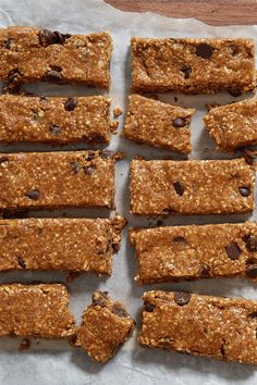 a bunch of granola bars sitting on top of a piece of paper next to a box of chocolate chips