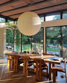 a dining room table with chairs and a large lantern hanging from it's ceiling