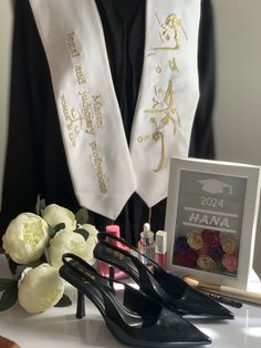 the graduation sash is next to some shoes and other items on a table with flowers