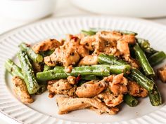 a white plate topped with chicken and green beans