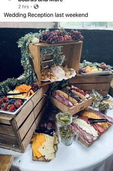 a table topped with lots of different types of cheese and meats on top of wooden crates