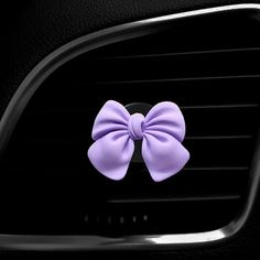 a car air vent with a purple bow on it